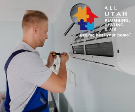 White male with short blond hair holding a screw driver and tightening a screw on a wall air conditioner